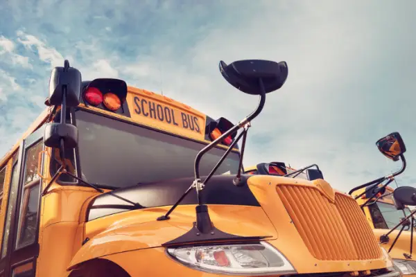 Yellow school bus against autumn sky. Back to school concept. Vintage filter effects.