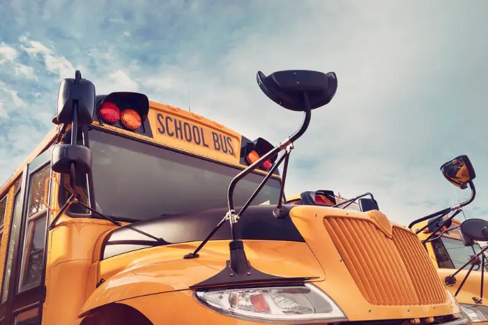 Yellow school bus against autumn sky. Back to school concept. Vintage filter effects.