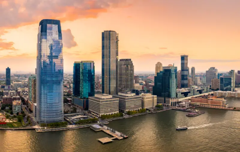 Aerial panorama of Jersey City skyline at sunset.