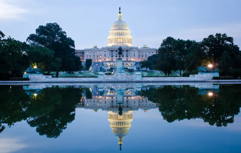 Washington DC, US Capitol Building in a cloudy sunrise with mirror reflection