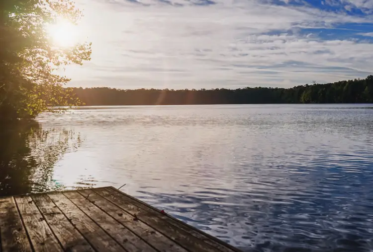 The sun rising in Chesapeake, Virginia USA at a local park with a lake.