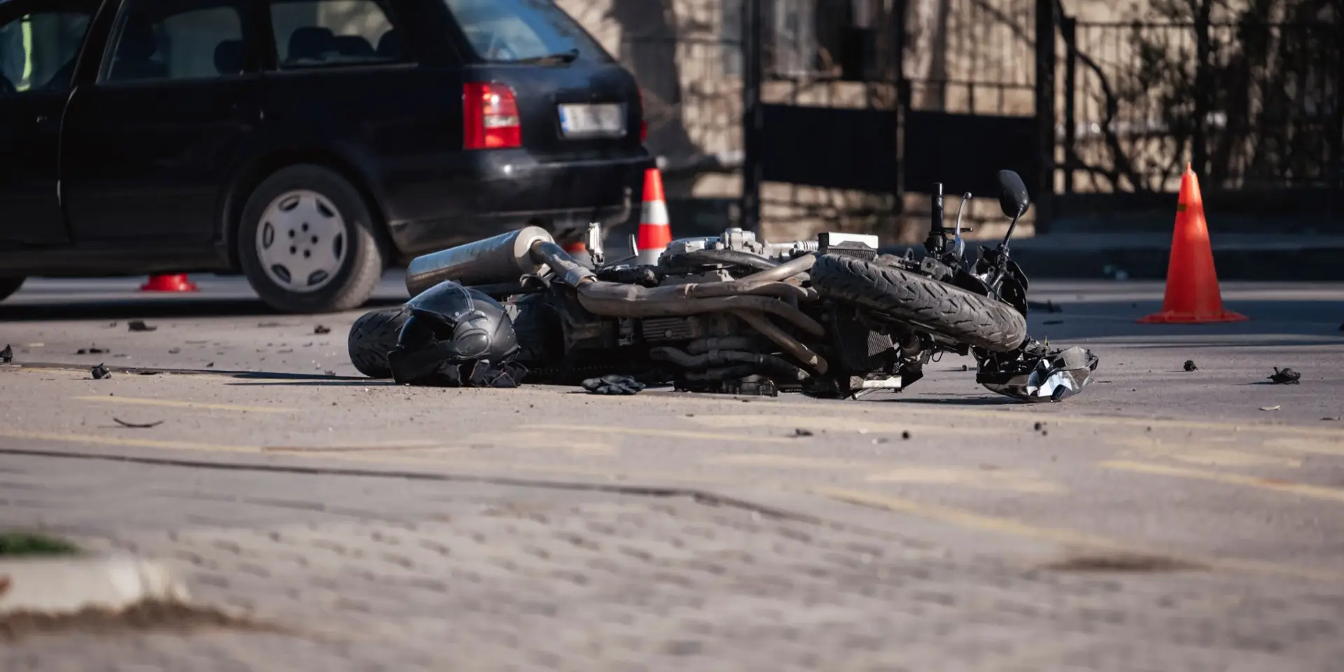 Accident with motorcycle at a crossroads. A motorcyclist's helmet lies next to a broken bike. Oil leaked from the bike. The motorcyclist was taken