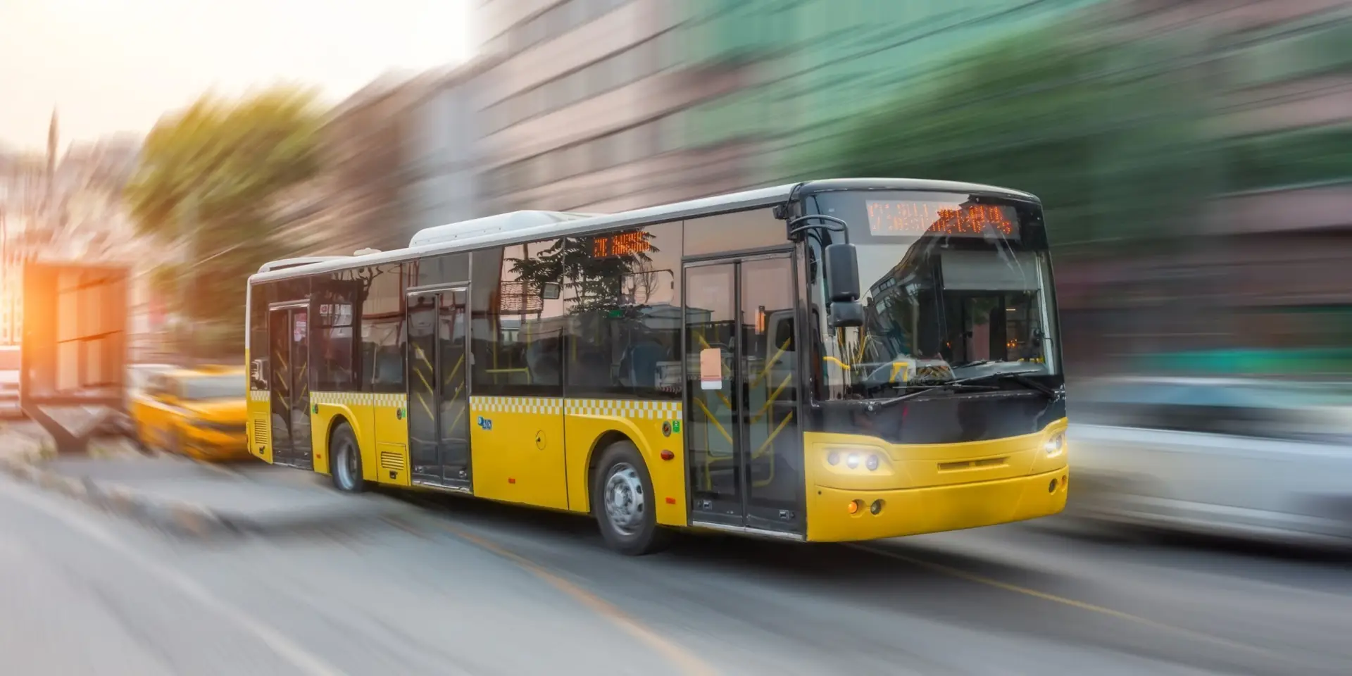 City yellow bus rush motion blur effect through the streets of the city in the evening at sunset peak hour