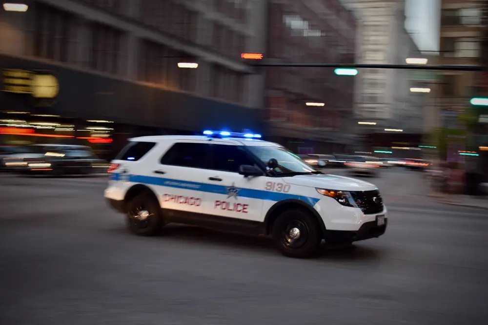 $27 Million Settlement | A Chicago police car speeds through an intersection.